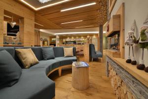 salon z niebieską kanapą i stołem w obiekcie Kristiania Pure Nature Hotel & Spa w mieście Cogolo