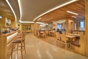 restauracja z drewnianymi ścianami, stołami i krzesłami w obiekcie Kristiania Pure Nature Hotel & Spa w mieście Cogolo