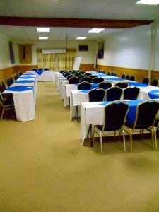 uma sala cheia de mesas e cadeiras com mesas azuis e brancas em Blue Mountain Inn Lesotho em Teyateyaneng