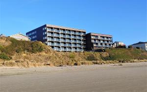 a building on top of a hill next to the beach at Starfish Manor Oceanfront Hotel in Lincoln City