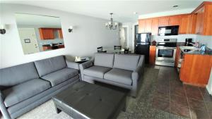 ein Wohnzimmer mit 2 Sofas und einer Küche in der Unterkunft Starfish Manor Oceanfront Hotel in Lincoln City