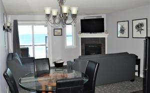 ein Wohnzimmer mit einem Tisch, Stühlen und einem TV in der Unterkunft Starfish Manor Oceanfront Hotel in Lincoln City