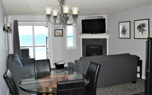 a living room with a table and chairs and a television at Starfish Manor Oceanfront Hotel in Lincoln City