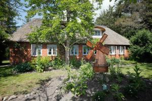 ein Haus mit einer Windmühle davor in der Unterkunft Urlaub im Friesenhaus in Langenhorn