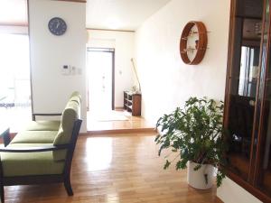 a living room with a couch and a plant at Rental Villa Luana Waioli in Tomigusuku