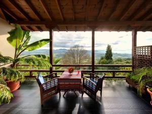 una mesa y sillas en un porche con vistas en Hotel El Mirador de Ordiales, en Careses