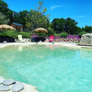 a large swimming pool with chairs and a beach at Chambres d'hôtes Le Cartounier in Pinel-Hauterive