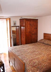 a bedroom with a large bed with wooden furniture at CASE CARMELI - Primula in Triora