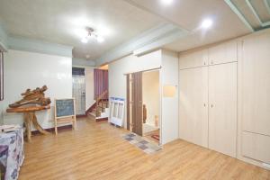 un soggiorno con pareti bianche e pavimenti in legno di Dons Young Homestay a Ruisui