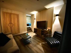 a living room with a couch and a television at Alvarado Loft Rural in Ubrique