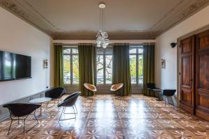 瓦龍的住宿－Hôtel Mille Pas，客厅配有椅子和平面电视