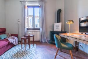 ein Wohnzimmer mit einem Sofa, einem Tisch und einem Schreibtisch in der Unterkunft Wine Apartments Florence Franciacorta in Florenz