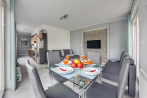 a dining room and living room with a table and chairs at Apartamenty Sun & Snow Promenada I in Świnoujście