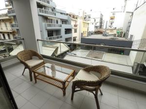 een balkon met 2 stoelen, een tafel en een raam bij Dreamstudio II in Volos