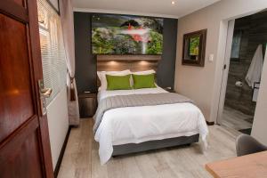 a bedroom with a bed and a television on the wall at Vinique Guesthouse in Nelspruit
