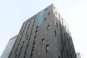 首爾的住宿－明洞托馬斯酒店，一座高大的灰色建筑,上面有窗户