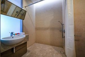 La salle de bains est pourvue d'un lavabo et d'une douche. dans l'établissement Dorsett Putrajaya, à Putrajaya