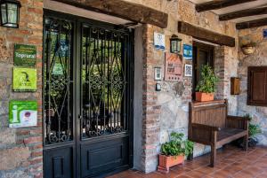 a entrance to a building with a black door and a bench at Hotel Rural Los Molinillos in El Arenal