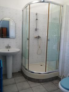 a bathroom with a glass shower and a sink at Villa Butterfly in Moragalla