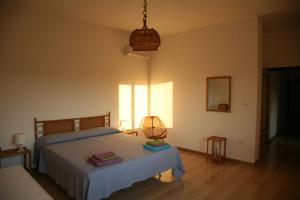 Un dormitorio con una cama y una lámpara. en Casa Solento, en Maruggio
