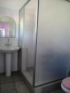 a bathroom with a shower and a sink at Villa Butterfly in Moragalla