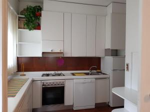 cocina con armarios blancos y fogones en Appartamento "Villa BMC", en Porto San Giorgio