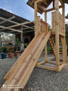 een houten speelhuis met een glijbaan bij Magnito in Shekhvetili