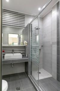 a bathroom with a glass shower and a sink at Mediterranean Beach Hotel in Skala Rachoniou