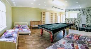 um quarto com uma mesa de bilhar e duas camas em Zolotoy Bereg Hotel em Zatoka