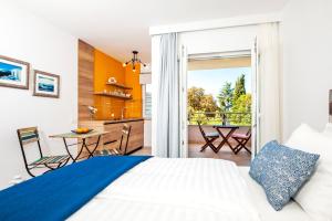 um quarto com uma cama e uma cozinha com uma varanda em Villa Marea em Rovinj