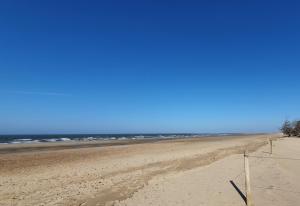 an empty beach with the ocean in the background at Boutique Bedrooms in Thornham