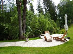 a patio with two chairs and an umbrella at Apartments Kokl - Adults only in Radovljica