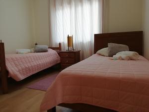 ポルティマンにあるAlltravel Primavera Apartmentのベッドルーム1室(ピンクの掛け布団付きのベッド2台付)