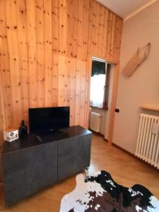 a living room with wooden walls and a table at Appartamento GARDEN Ponte di Legno in Ponte di Legno