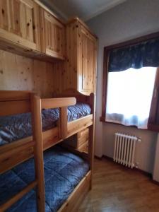 a room with two bunk beds and a window at Appartamento GARDEN Ponte di Legno in Ponte di Legno