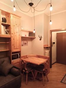 um quarto com uma mesa de madeira e um sofá em Appartamento GARDEN Ponte di Legno em Ponte di Legno