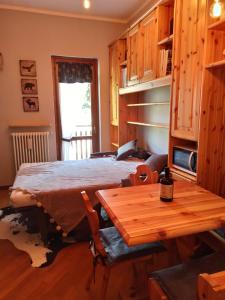 1 dormitorio con cama y mesa de madera en Appartamento GARDEN Ponte di Legno, en Ponte di Legno