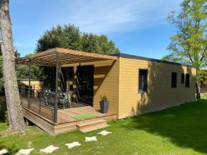 een kleine hut met een terras en een boom bij Les Troglodytes du Ventoux in Bollène