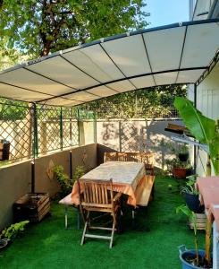 patio con tavolo e sedie sotto un baldacchino di Appartamento Margherita a Quartu SantʼElena