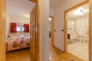 a bedroom with a bed and a bathroom at Apartments Rozle in Kranjska Gora