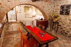 a dining room with a table and a bed in a room at B&B Borgo di Oliveto - Appartamenti con Cucina in Civitella in Val di Chiana