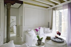 ein Wohnzimmer mit einem weißen Sofa und einem Tisch mit Blumen in der Unterkunft White Home in Florenz