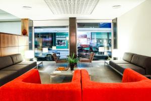 a living room with a red couch and a table at Hotel Praia in Nazaré