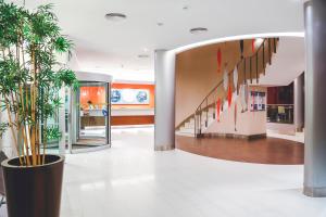 a lobby with a staircase and a potted plant at Hotel Praia in Nazaré +37 photos
