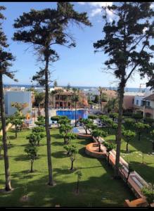 vistas a un parque con árboles y una piscina en Omega Platanias en Plataniás