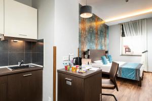 a bedroom with a bed, desk and a refrigerator at Opera Garden Hotel & Apartments in Budapest