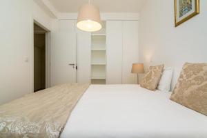 リスボンにあるWHome | Graça Premium Apartment #27のベッドルーム(白いベッド1台、ランプ付)