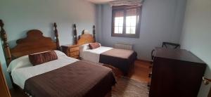 1 dormitorio con 2 camas y TV. en Villa Ibio, en Riaño de Ibio