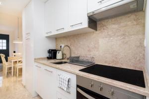 リスボンにあるWHome | Graça Premium Apartment #23の白いキャビネットとシンク付きのキッチン