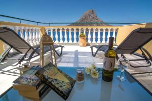 un tavolo di vetro con una bottiglia di vino e libri di ELENA APARTMENTS a Masouri